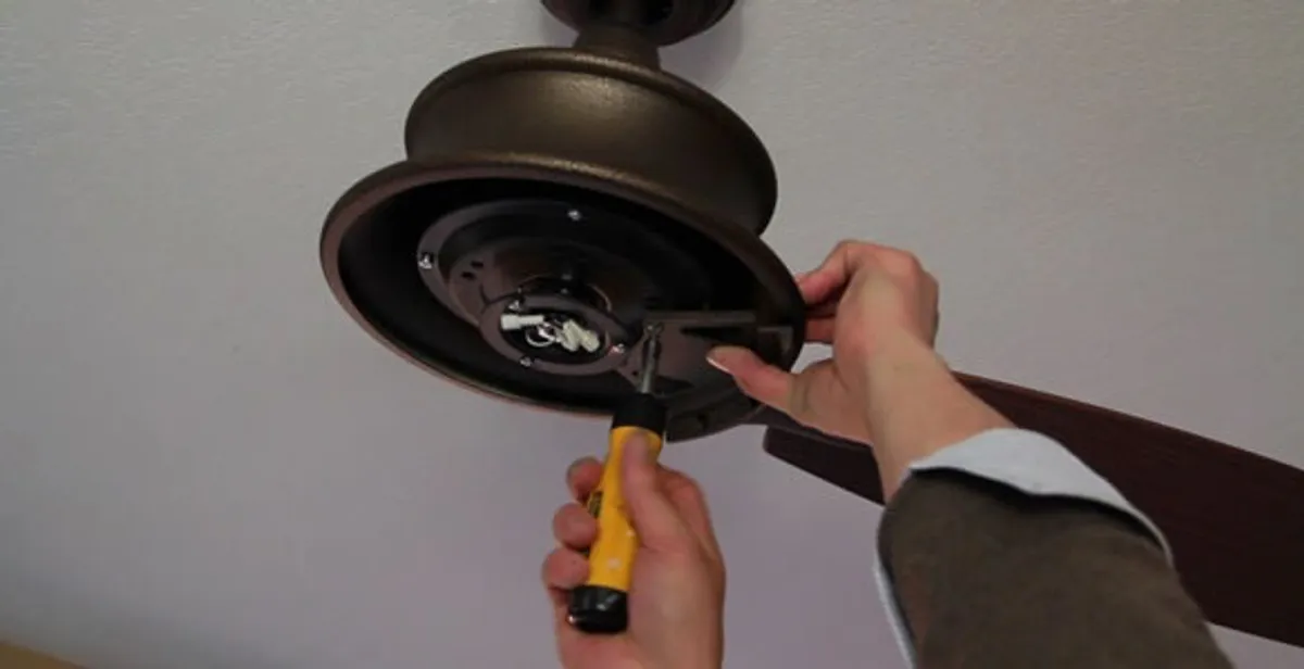 Electrician installing ceiling fan mounting bracket and fixture in Atlanta, GA
